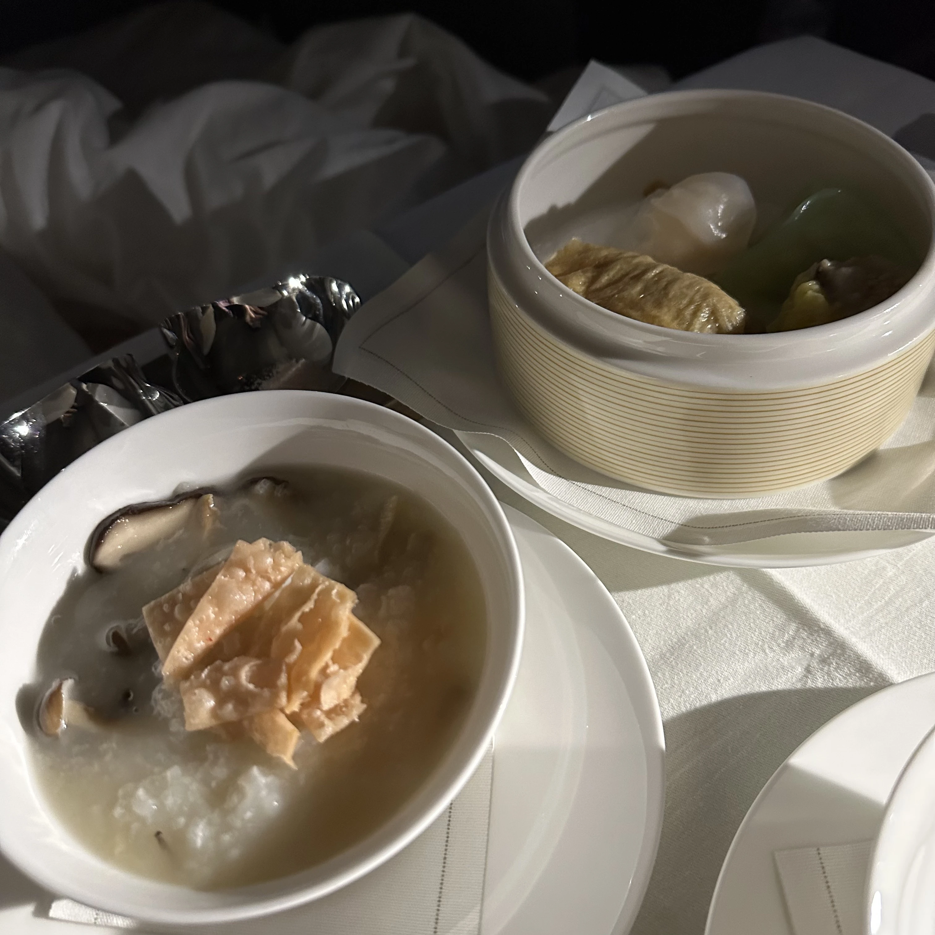 Cathay Pacific First Class breakfast with traditional congee and dim sum dishes.