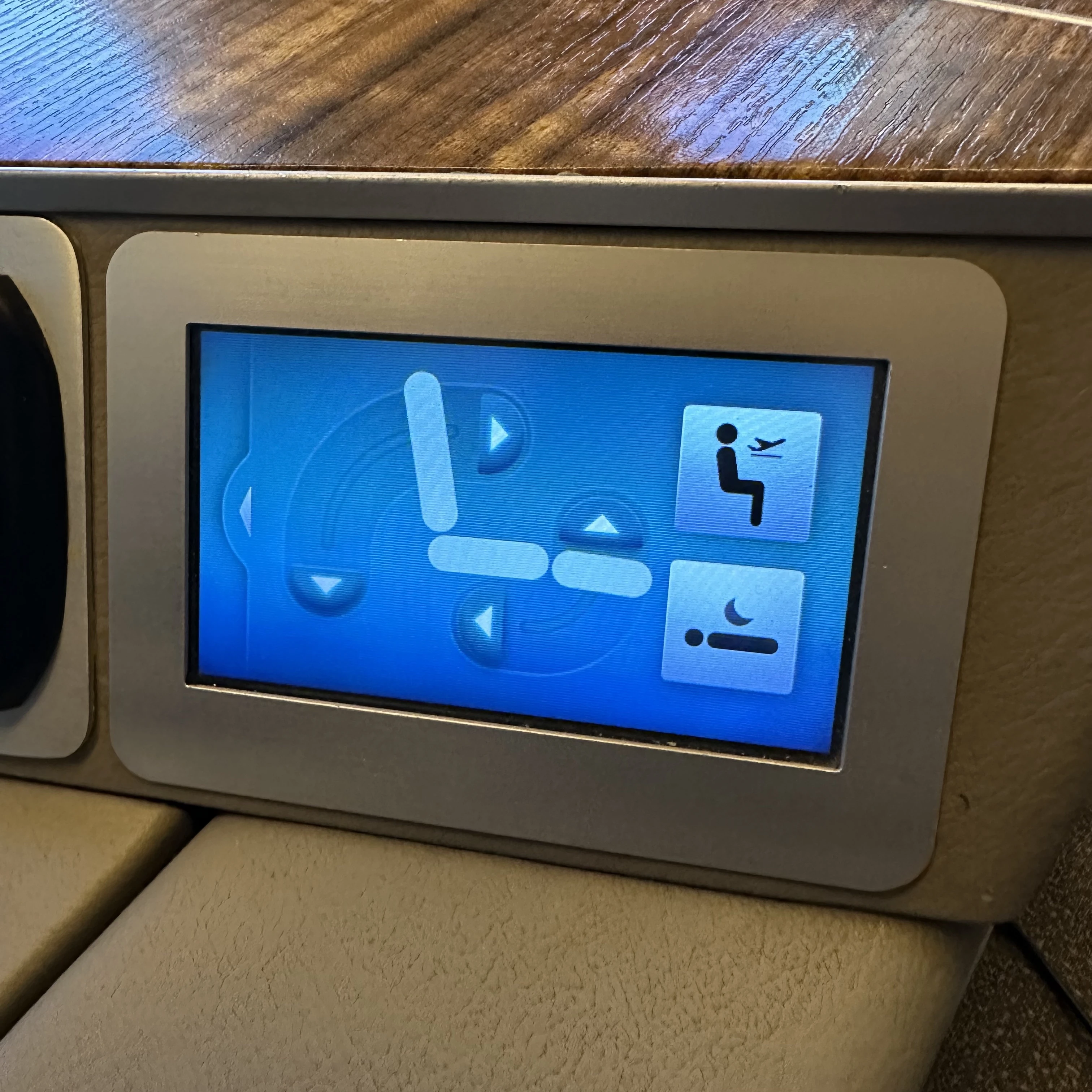 Cathay Pacific First Class seat adjustment controls for reclining and comfort settings.