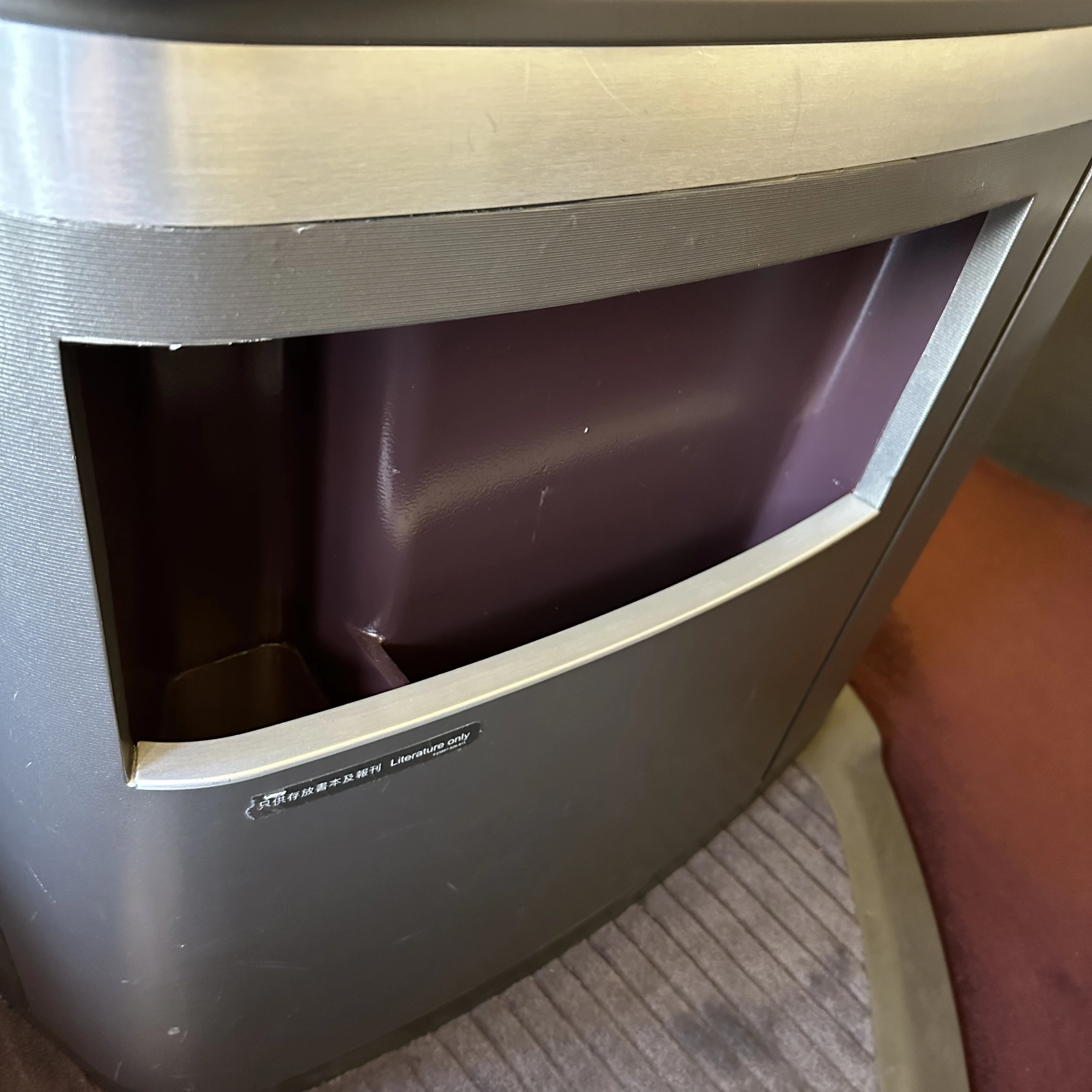 Cathay Pacific First Class seat storage compartments for convenient luggage organization.