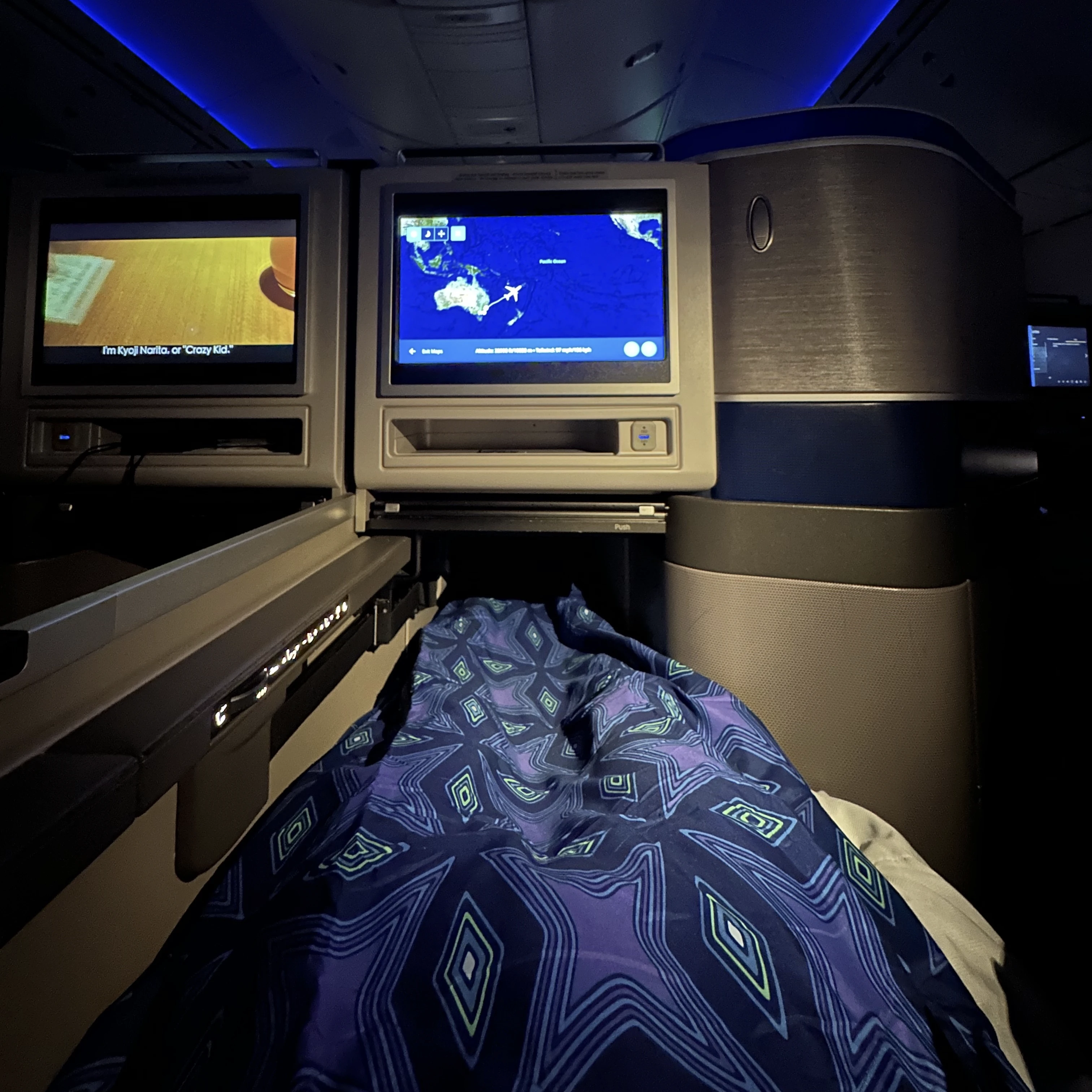 Lie-flat bed in United Polaris Business Class with a high-quality duvet for added comfort.