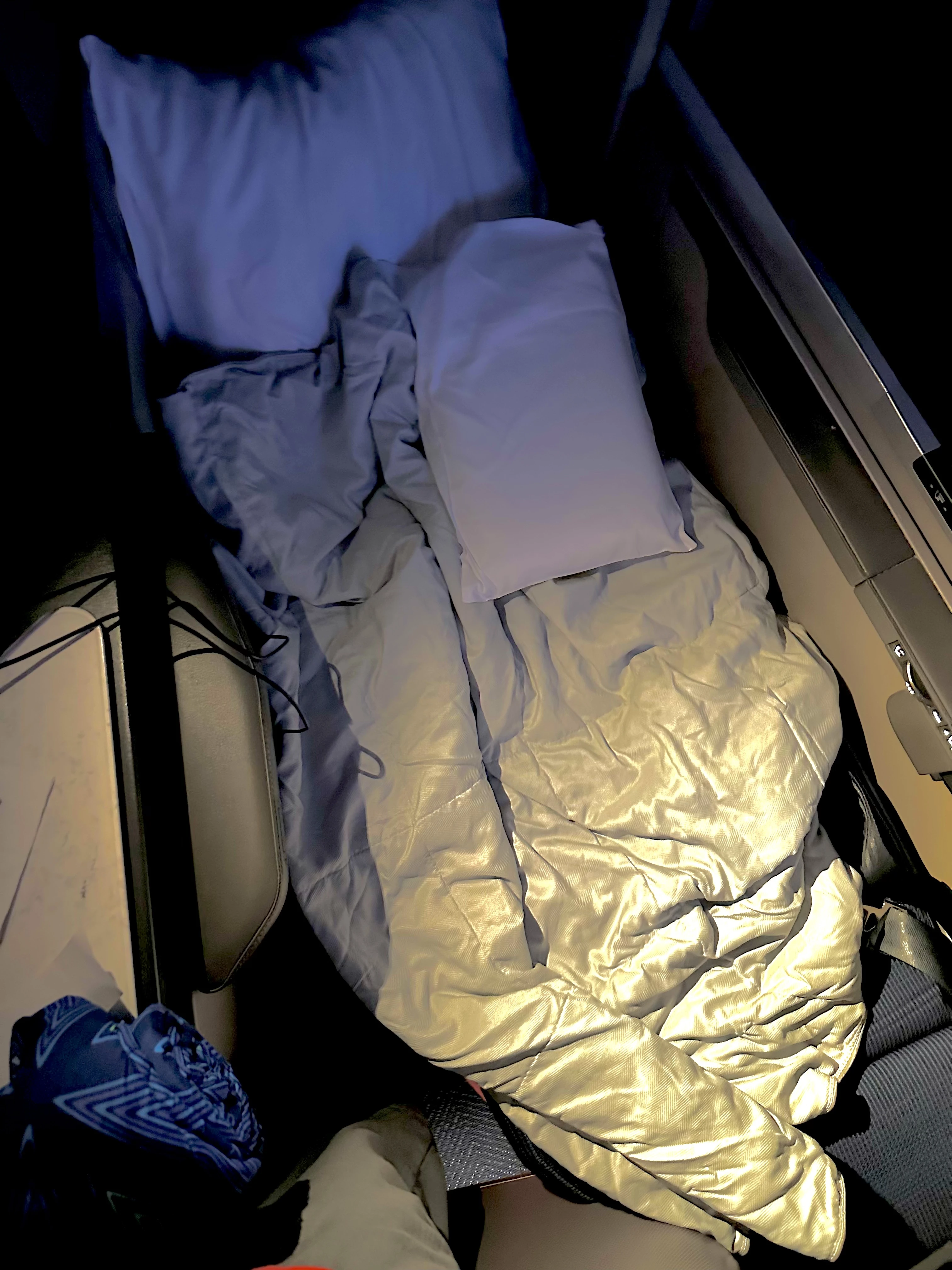 Lie-flat bed in United Polaris Business Class with ample plush bedding for a comfortable rest