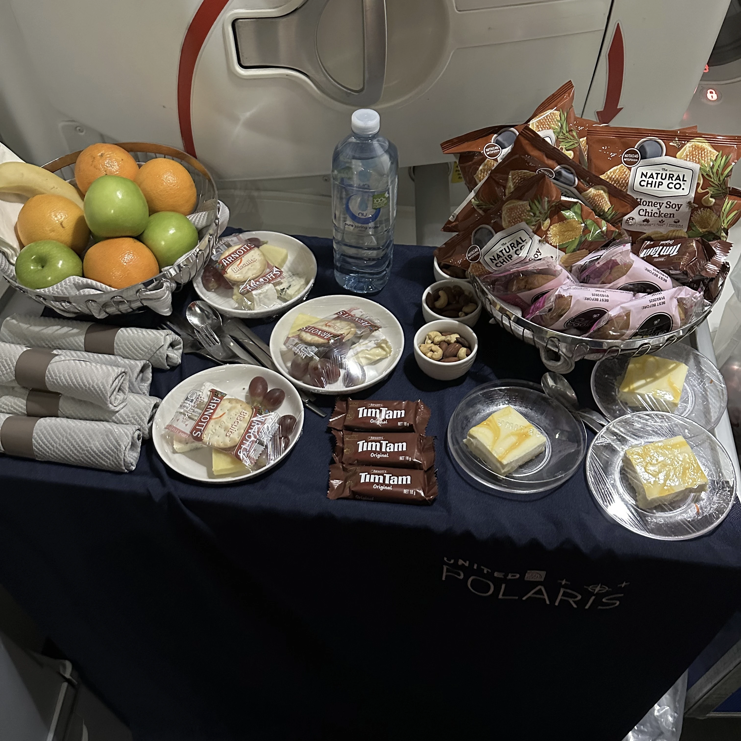 Snack selection available in the galley of United Polaris Business Class, including popular options like Tim Tams.